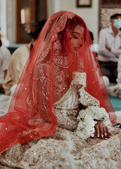 red and white nikkah dress There is nothing more beautiful than the simplicity of an off white nikkah dress. Our bride looks ravishing in our off white gharara with ruby red roses. The ensemble takes a classical